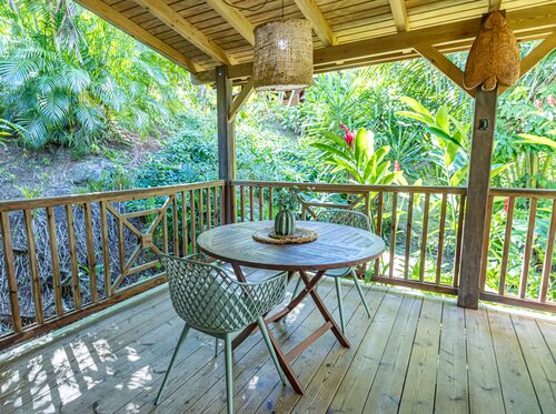 Terrasse extérieure avec une table dans la villa Ti Kaz Bwa de l'hôtel Caraïb'Bay Hôtel