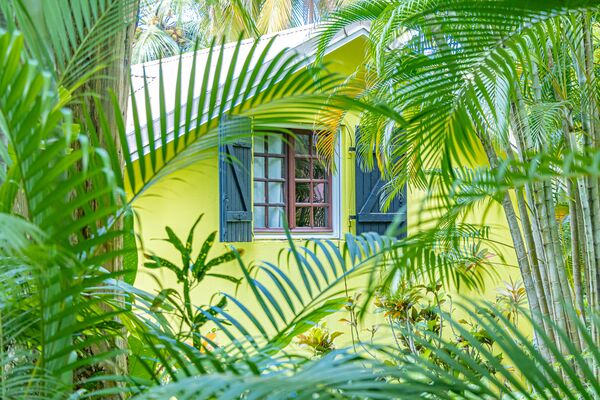 Vue extérieure à travers la végétation d'une villa du Caraïb'Bay Hôtel