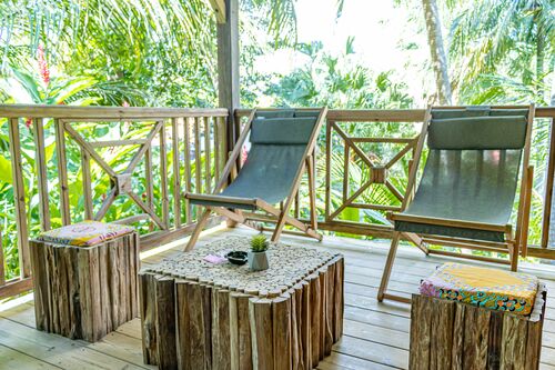 Terrasse extérieure confortable avec deux chaises longues avec reposes-pied et une table basse dans la villa Ti Kaz Bwa de l'hôtel Caraïb'Bay Hôtel