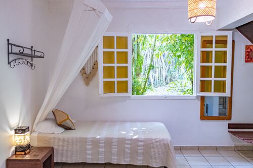Photo intérieure d'une fenêtre d'un duplex du Caraib'Bay Hôtel avec vue sur le lit et la table de chevet