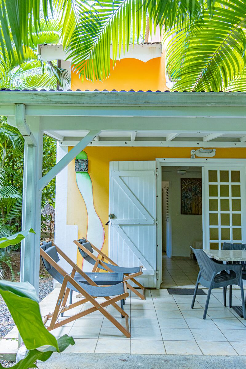 Vue d'une terrasse extérieure avec deux chaises longues au Caraïb'Bay Hôtel